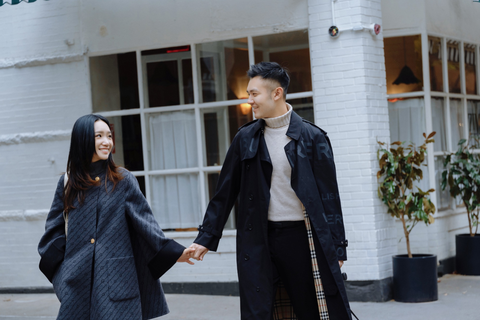 A couple holding hands outside a café