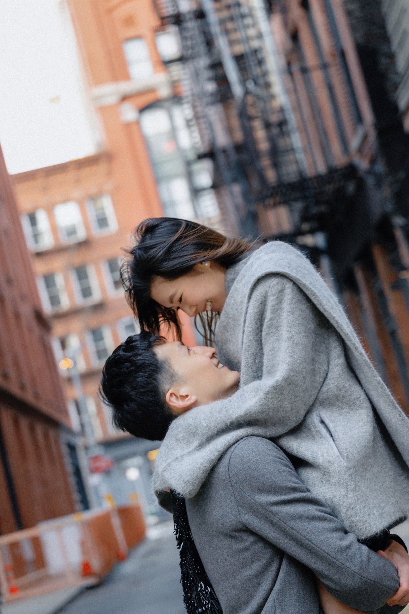 A laughing couple embracing on a city street